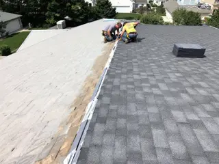 Roof replacement in progress: half the slope on new underlayment, the rest already shingled