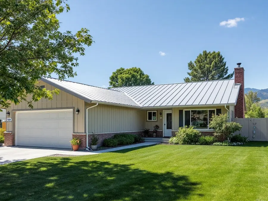 Single-story home with a light gray metal roof on a sunny summer day
