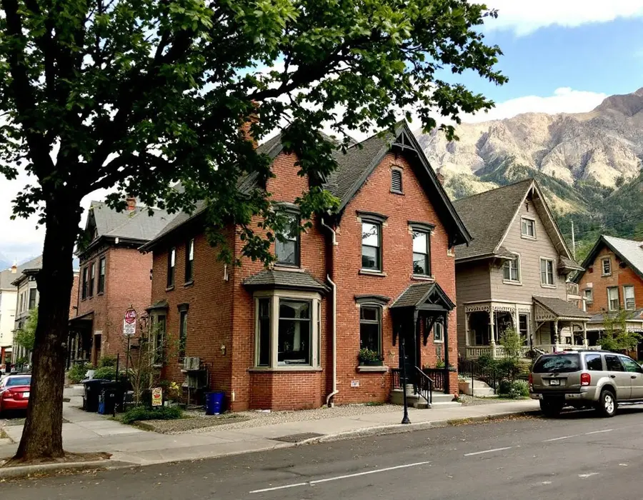 Brick Victorian home on a tree-lined Ogden street with mountains close behind