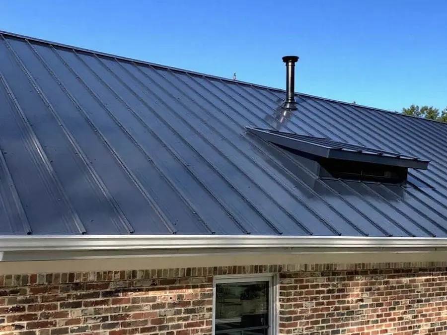 Ranch home with a dark gray standing seam roof, each panel running unbroken from gutter to ridge
